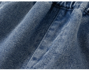 Dettaglio macro del tessuto denim blu scuro con doppia cucitura e vita elastica rifinita