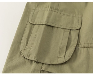 Detalle del bolsillo tipo cargo con solapa y pliegues en pantalón de sarga verde
