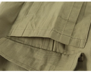 Detalle del bolsillo cargo verde oliva con costura de doble aguja en pantalón de niño