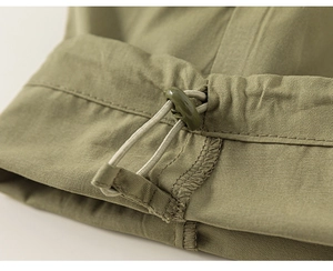 Detalle de pantalón cargo verde militar con cordón elástico y cierre de ajuste fácil