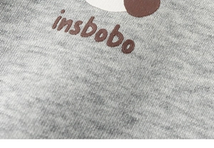 Dettaglio del tessuto in maglia grigio melange con logo insbobo marrone stampato