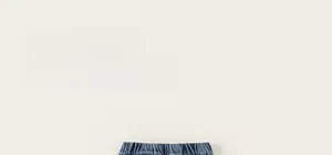 Dettaglio dei jeans in denim blu per bambini con vita elastica e design a pieghe