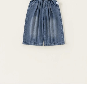 Dettaglio dei pantaloni in denim blu scuro a gamba larga con elastico e cuciture verticali
