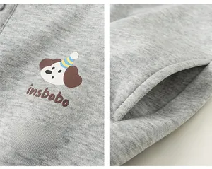 Dettaglio della stampa del cane e della tasca laterale della felpa polo in maglia grigia da bambino