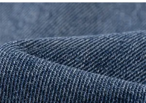 Macro della trama del tessuto denim twill blu resistente per pantaloni da bambina