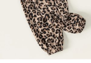 Dettaglio dei pantaloni leopardati per bambini con caviglie elasticizzate e tessuto liscio