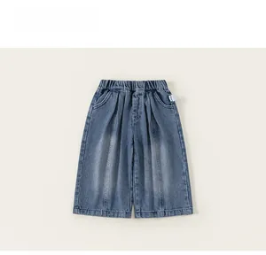 Dettaglio di pantaloni in denim da bambina con vita elastica e pieghe alla moda sul davanti