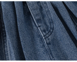 Vista macro del tessuto denim blu con trama diagonale e cuciture a contrasto