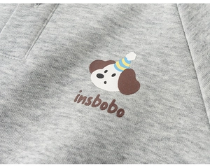 Dettaglio del tessuto in maglia grigia con stampa di cane e texture fine del set per bambini