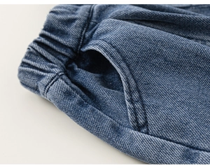 Dettaglio della vita elastica e della tasca su questi jeans in denim blu da bambina