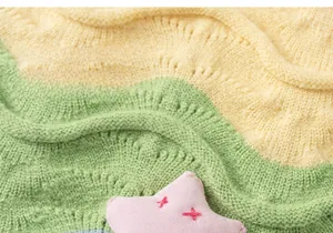 Detail of green and yellow wavy knitted fabric with a pink star crochet ornament