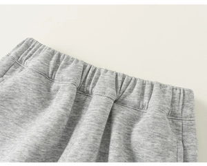 Dettaglio dei pantaloni grigi da bambino con elastico in vita e trama in morbido cotone
