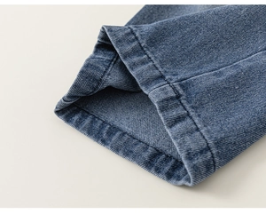 Dettaglio ravvicinato dell'orlo a doppia cucitura sui jeans dritti in denim blu lavato
