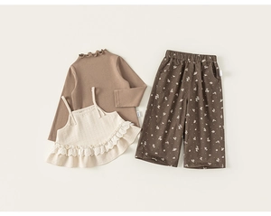 Détail du t-shirt en tricot marron à col volanté et de l'ensemble à fleurs beige