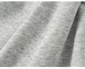 Dettaglio macro del tessuto a maglia grigio melange e cuciture rifinite del set per bambini