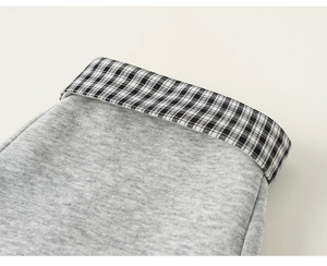 Dettaglio del tessuto a maglia grigio con cuciture a contrasto gingham bianco e nero