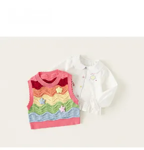 Detail of girls white shirt with peter pan collar and colorful striped knit vest set