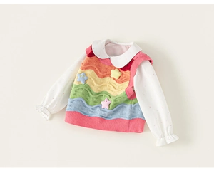 Close-up of rainbow striped knit vest with 3D star patches and white dotted shirt collar
