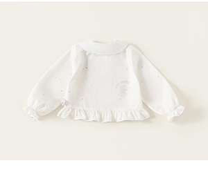 Detail of baby girl white cotton shirt with colorful polka dots and ruffled Peter Pan collar