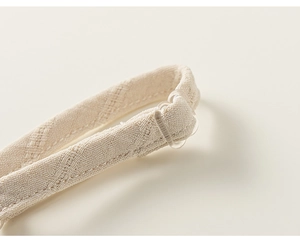 Détail de bretelle tricotée crème avec boucle réglable pour ensemble fille trois pièces