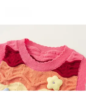 Detail of colorful wavy knit pattern and 3D yellow flower on a girl's sweater vest