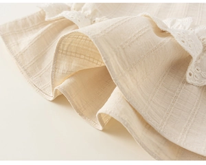 Détail macro du tissu côtelé beige avec broderie de dentelle florale blanche délicate