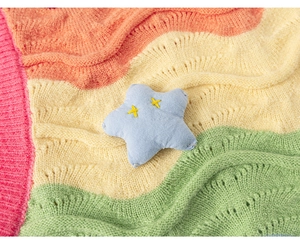 Detail of colorful wavy knit fabric with eyelet texture and blue star embroidery charm