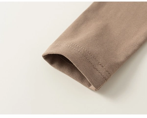 Vue macro des poignets en maille marron moka avec détails de couture à double aiguille