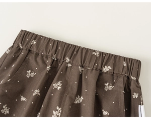 Détail du pantalon floral pour enfant avec taille élastique et tissu imprimé marron