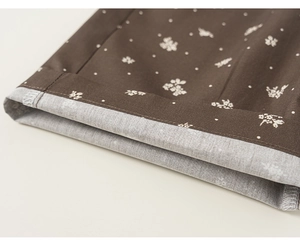 Détail du revers floral café avec coutures soignées et doublure en lin gris pour enfant