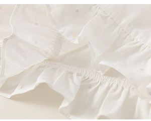 Detail of white cotton shirt with colorful polka dots and tiered ruffle stitching