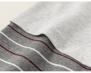 Macro su tessuto in maglia grigio melange con sottili strisce rosse e cuciture piatte