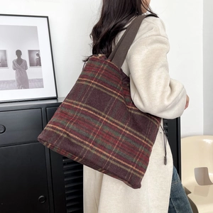 Detail view of retro plaid wool tote bag featuring wide strap and metallic charm