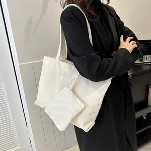 Detail of white corduroy tote bag texture with fashion label and matching pouch
