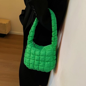 Detail of a neon green quilted puff shoulder bag with a unique square texture pattern