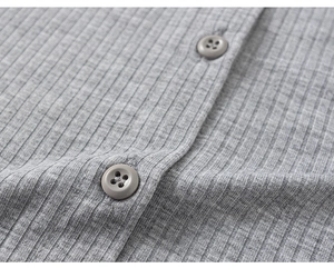 Close-up of grey ribbed cotton fabric and brown resin buttons on a girl's T-shirt