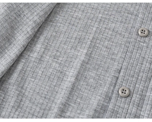 Close-up of grey ribbed fabric texture with two matching four-hole buttons on a girl's shirt