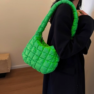 Detail of neon green quilted cloud bag featuring bubble texture on shiny fabric surface