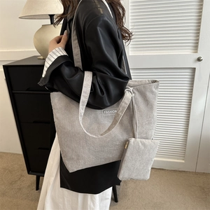 Detail view of gray corduroy tote and pouch set worn by model in a modern home
