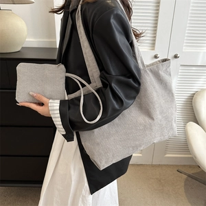 Detail of grey corduroy tote bag with textured stripes and matching small zipper pouch