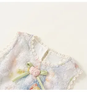 Détail du tissu floral en peluche avec col en dentelle blanche et décoration en ruban vert