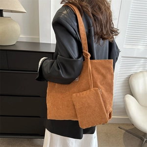 Detail of a brown corduroy tote bag set with a knotted shoulder strap and matching pouch