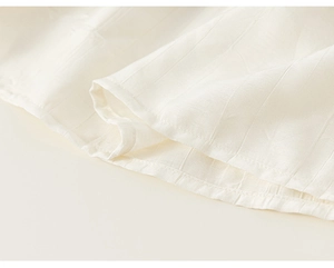 Gros plan sur la texture côtelée blanche et les coutures de la robe fleurie pour enfant