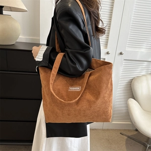 Detailed close-up of a brown corduroy tote bag featuring a textured vertical stripe finish