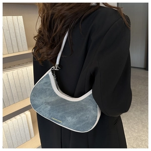 Detail of the blue denim half-moon underarm bag with white leather strap and fashion text