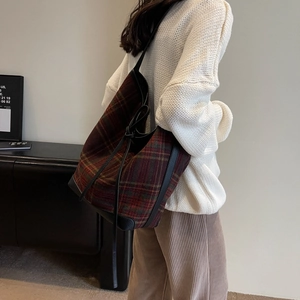 Detail of tartan wool shoulder bag with leather drawstring strap and retro bucket shape