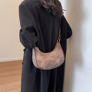 Détail du sac demi-lune en similicuir marron avec finitions dorées et coutures décoratives