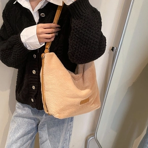 Vue détaillée du sac hobo en fausse fourrure beige avec bandoulière réglable en cuir brun
