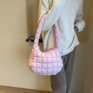 Pink quilted nylon puffer shoulder bag for women styled with a cozy white sweater