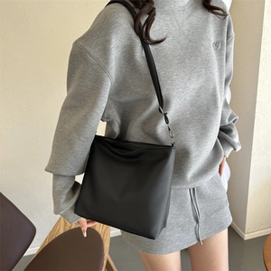Close-up of black PU leather shoulder bag with lychee texture and silver metal hardware